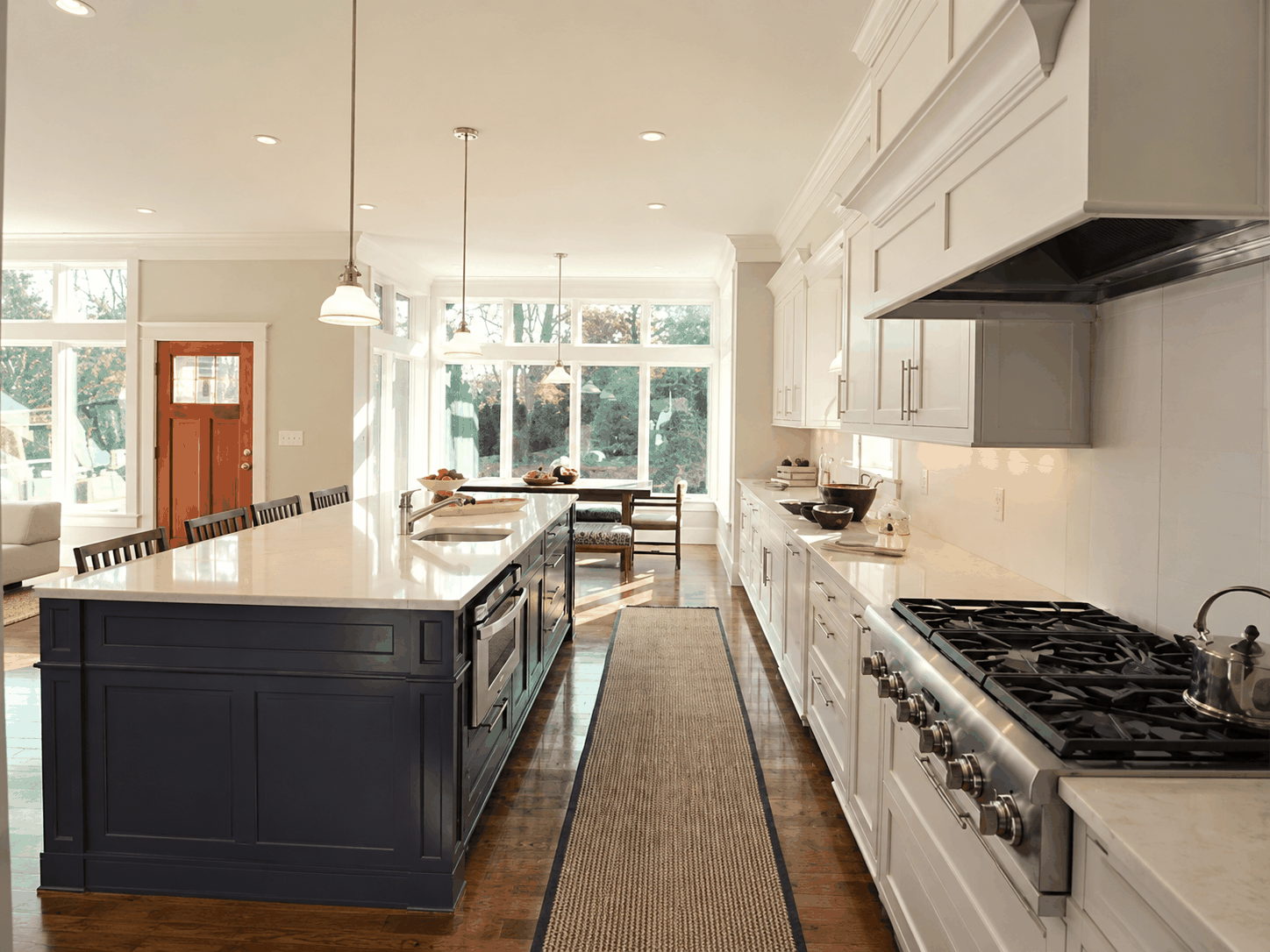 Custom kitchen remodeling with large island, white cabinetry, and professional range